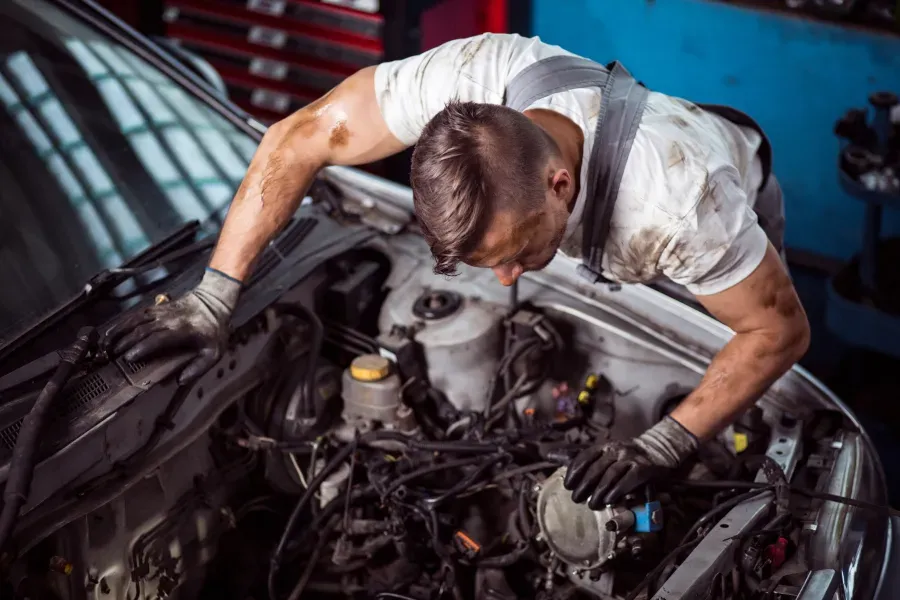 mechanic-working-on-vehicle-covered-in-grease
